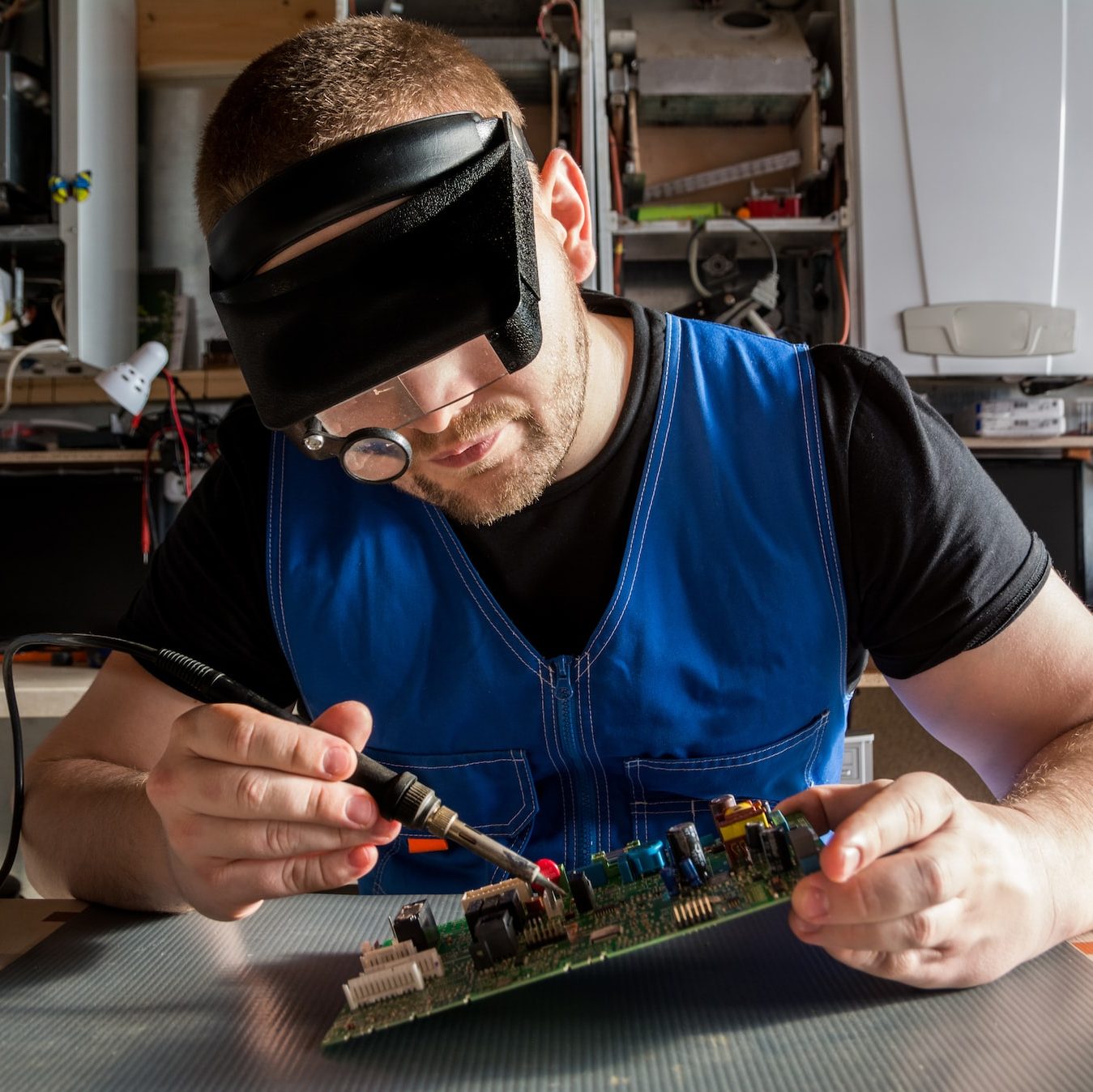 a man wearing a blindfold working on a circuit board